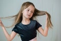 Close-up portrait of happy smiling little girl holding in hands her long hair Royalty Free Stock Photo