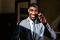 Happy smiling young man in business suit holding cell phone, talking and looking at camera Royalty Free Stock Photo