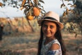 Close up portrait of happy teen girl with healthy skin in white hat and dress standing in the garden, two pears are Royalty Free Stock Photo