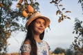 Close up portrait of happy teen girl with healthy skin in white hat and dress standing in the garden, two pears are Royalty Free Stock Photo