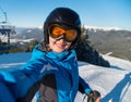 Close-up portrait of happy woman skier smiling, taking a selfie while resting on the slope after skiing Royalty Free Stock Photo