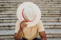 Close up portrait of a happy young african american man hides his face behind a straw hat. Royalty Free Stock Photo