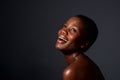 Close up happy young african woman with naked shoulders laughing on gray background Royalty Free Stock Photo