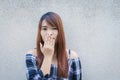 Close up portrait of happy young asian woman smiling and winking against gray concrete wall. Vintage tone filter color style Royalty Free Stock Photo