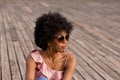 close up portrait of a Happy young beautiful afro american woman sitting on wood floor and smiling. Spring or summer season. Royalty Free Stock Photo