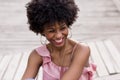 close up portrait of a Happy young beautiful afro american woman sitting on wood floor and smiling. Spring or summer season. Royalty Free Stock Photo