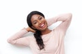 Close up happy young black woman laughing with hands behind head against white wall Royalty Free Stock Photo