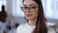 Close-up portrait, happy young brunette design professional business woman in eyeglasses smiling at camera at office. Royalty Free Stock Photo