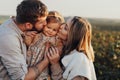 Close Up Portrait of Happy Young Caucasian Family Outdoors, Mother and Father Kissing Their Baby Daughter at Sunset Royalty Free Stock Photo