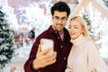 Close-up portrait of happy young couple taking selfie picture on mobile phone standing in hall of celebrate shopping Royalty Free Stock Photo