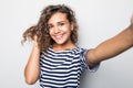Close up portrait of a happy young curly mulatto woman making selfie against isolated white background Royalty Free Stock Photo