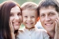 Close-up portrait of a happy young family. Mom, dad and little son look at the camera and smile. Royalty Free Stock Photo