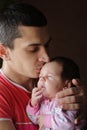 Close-up portrait of happy young father hugging and kissing his sweet adorable newborn child expressing tenderness enjoying sweet Royalty Free Stock Photo