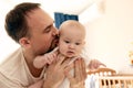 Close-up portrait of happy young father hugging and kissing his sweet adorable newborn child. Indoors shot, concept Royalty Free Stock Photo