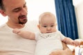 Close-up portrait of happy young father hugging and kissing his sweet adorable newborn child. Indoors shot, concept Royalty Free Stock Photo