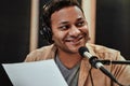 Close up portrait of happy young male radio host in headphones smiling aside while talking, broadcasting in studio Royalty Free Stock Photo