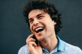 Close-up portrait of happy young man talking on mobile phone with his girlfriend. Happy male with curly hair resting outside Royalty Free Stock Photo