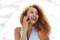 Close up happy young woman with curtly hair talking on mobile phone Royalty Free Stock Photo