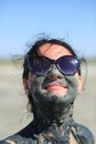 Closeup portrait of a happy young woman with a healing mud on her face. Natural medicinal clay therapy Royalty Free Stock Photo