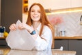 Close-up portrait of happy young woman playing pops bubble wrap to calm herself sitting at table in kitchen room. Royalty Free Stock Photo