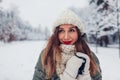 Close up portrait of happy young woman in snowy winter park wearing warm knitted clothes and red festive lipstick Royalty Free Stock Photo