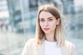 Close-up portrait of a happy young woman standing outdoors and smiling on blurred urban background looking at camera. Female Royalty Free Stock Photo