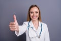 Close-up portrait of her she nice attractive cheerful cheery glad friendly blonde girl doc physician giving thumbup ad Royalty Free Stock Photo