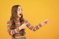 Close-up portrait of her she nice cute attractive cheerful amazed girl pointing aside on copy space isolated on yellow Royalty Free Stock Photo