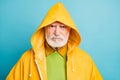 Close-up portrait of his he gloomy dissatisfied grey-haired man wearing yellow topcoat dislike bad weather isolated over