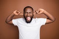 Close-up portrait of his he nice attractive annoyed crazy frustrated bearded guy wearing white tshirt closing ears with