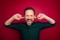 Close-up portrait of his he nice attractive crazy mad bearded brown-haired man suffering from migraine closing ears