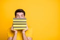 Close-up portrait of his he nice attractive funny brunette guy holding in hands hiding behind pile of book scary Royalty Free Stock Photo