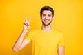 Close-up portrait of his he nice attractive funny cheerful cheery guy wearing tshirt showing v-sign good mood isolated
