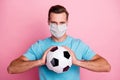 Close-up portrait of his he nice attractive guy wearing safety mask holding in hands ball professional player mers cov