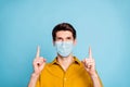 Close-up portrait of his he nice healthy guy wearing safety mask pointing up copy space information stop influenza mers