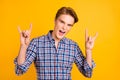 Close-up portrait of his he nice-looking attractive cool cheerful cheery guy wearing checked shirt showing horn symbol