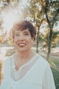 Close up portrait of a hispanic senior woman in the park at sunset Royalty Free Stock Photo