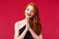 Close-up portrait of hopeful smiling european woman with red long curly hair, black dress and lipstick, hope you will Royalty Free Stock Photo