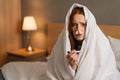 Close-up portrait of ill tired young woman suffering from runny nose disease with paper tissues into nose, measuring Royalty Free Stock Photo