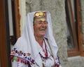 Portrait image of older woman laughing gaily wearing traditional village tribal clothing with headpiece