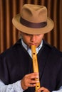 Close up portrait of indigenous young man playing the quena flute