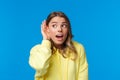 Close-up portrait of intrigued and curious blond young girl with pierced ear, gossiping, eavesdropping and listening to Royalty Free Stock Photo