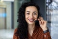 Close up portrait of latin american woman inside modern office with headset for video call, woman smiling and looking at Royalty Free Stock Photo