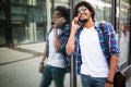 Close up portrait of laughing black young man talking on mobile phone and looking away Royalty Free Stock Photo