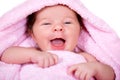 Close-up portrait of laughing smiling newborn baby on a pink terry-cloth towel Royalty Free Stock Photo