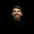 Close-up portrait of laughing young bearded man weared black turtleneck looking up Royalty Free Stock Photo