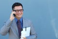 Close up portrait of laughing young businessman in talking by mobile phone over blue background Royalty Free Stock Photo