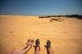 Close up portrait of legs,  legs of couples lying with a mixture of golden sand dunes.Feet of a man and a woman in sandals on the Royalty Free Stock Photo