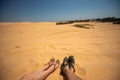 Close up portrait of legs,  legs of couples lying with a mixture of golden sand dunes.Feet of a man and a woman in sandals on the Royalty Free Stock Photo