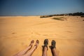 Close up portrait of legs, legs of couples lying with a mixture of golden sand dunes.Feet of a man and a woman in